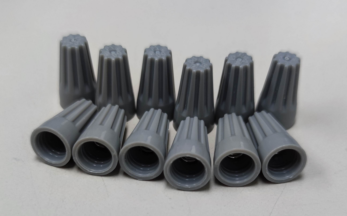 Gray Wire Nut Electrical Connector Caps arranged in two rows for electrical circuitry use